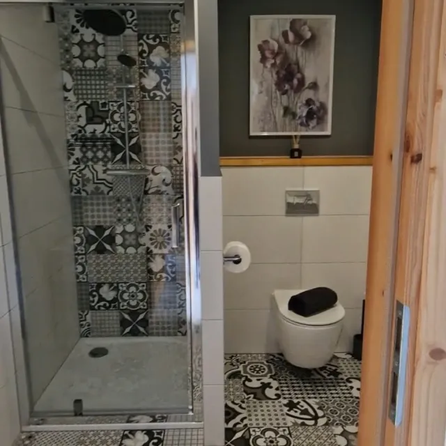 Łazienka z prysznicem i czarno-białą podłogą w apartamencie Białym