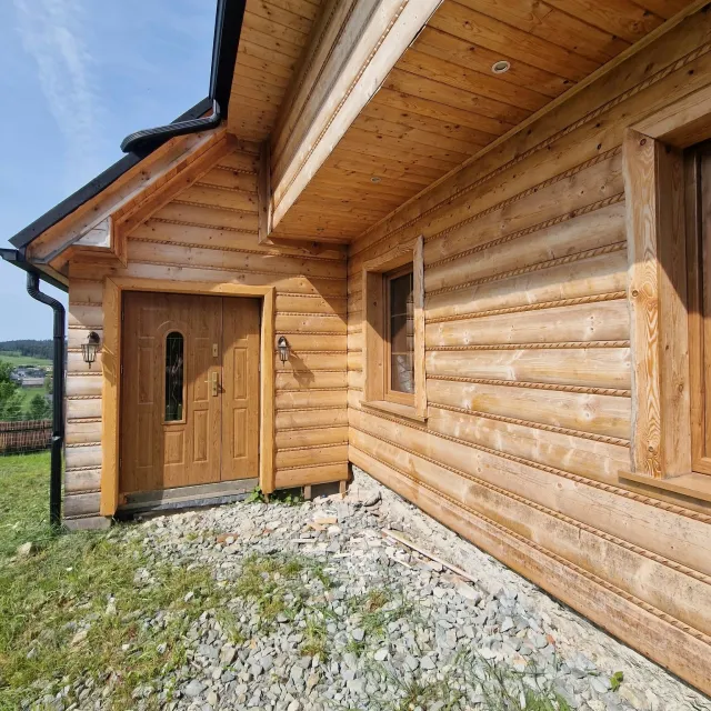 Drewniana elewacja domu i wejście do apartamentu