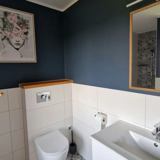 Łazienka z umywalką, toaletą i wzorzystą podłogą w apartamencie Szarym