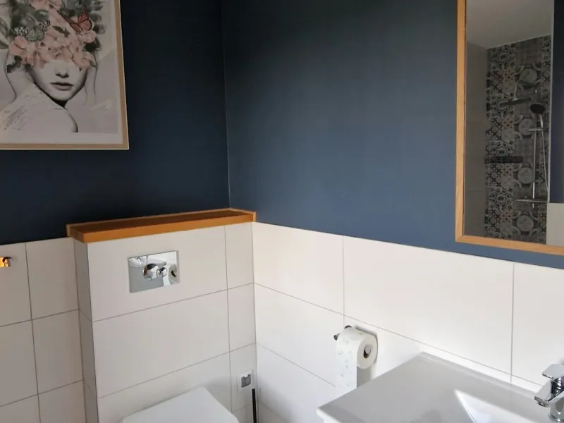 Łazienka z umywalką, toaletą i wzorzystą podłogą w apartamencie Szarym